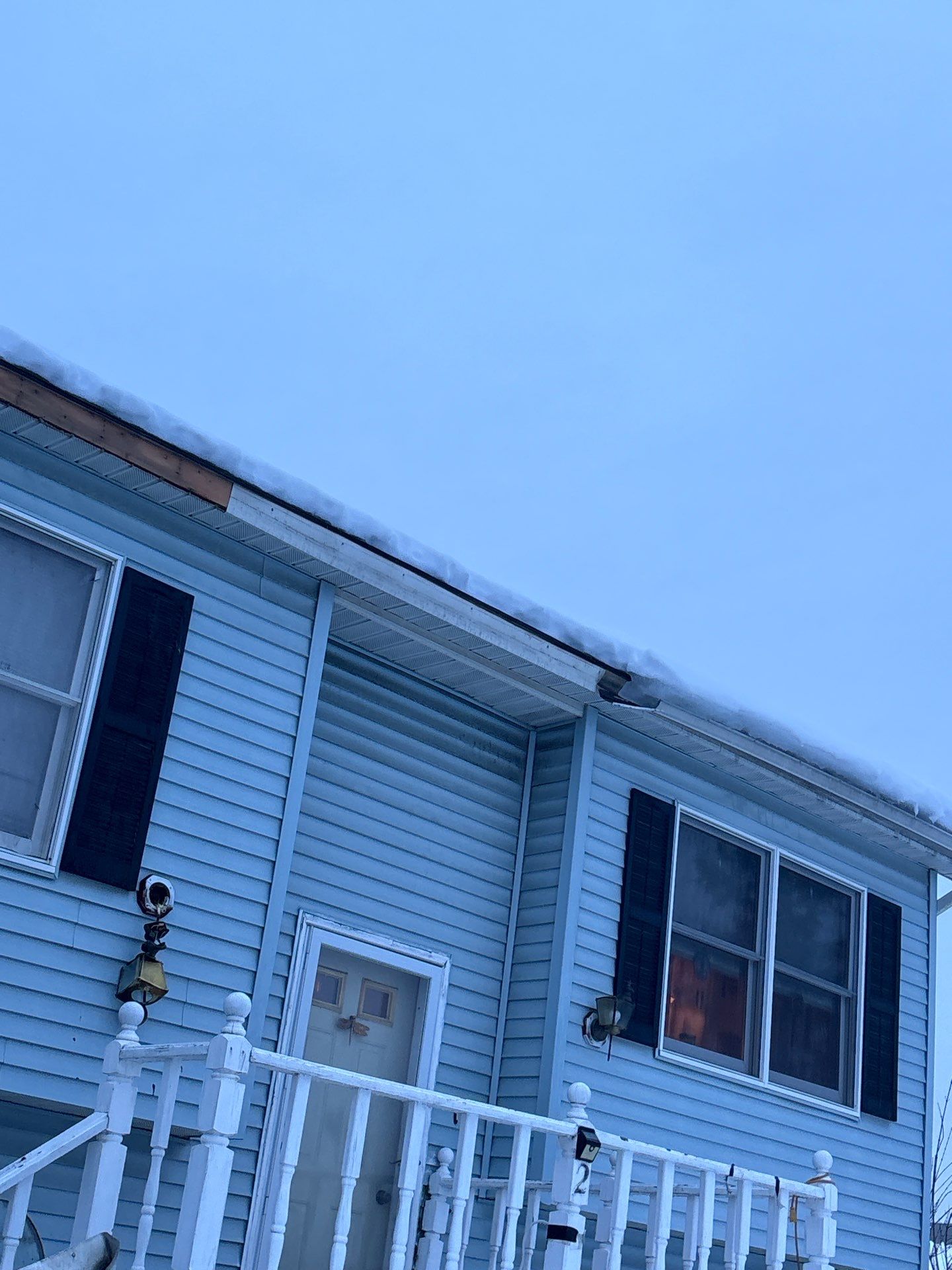 gutter pulled away from roofline by ice dam on blue house