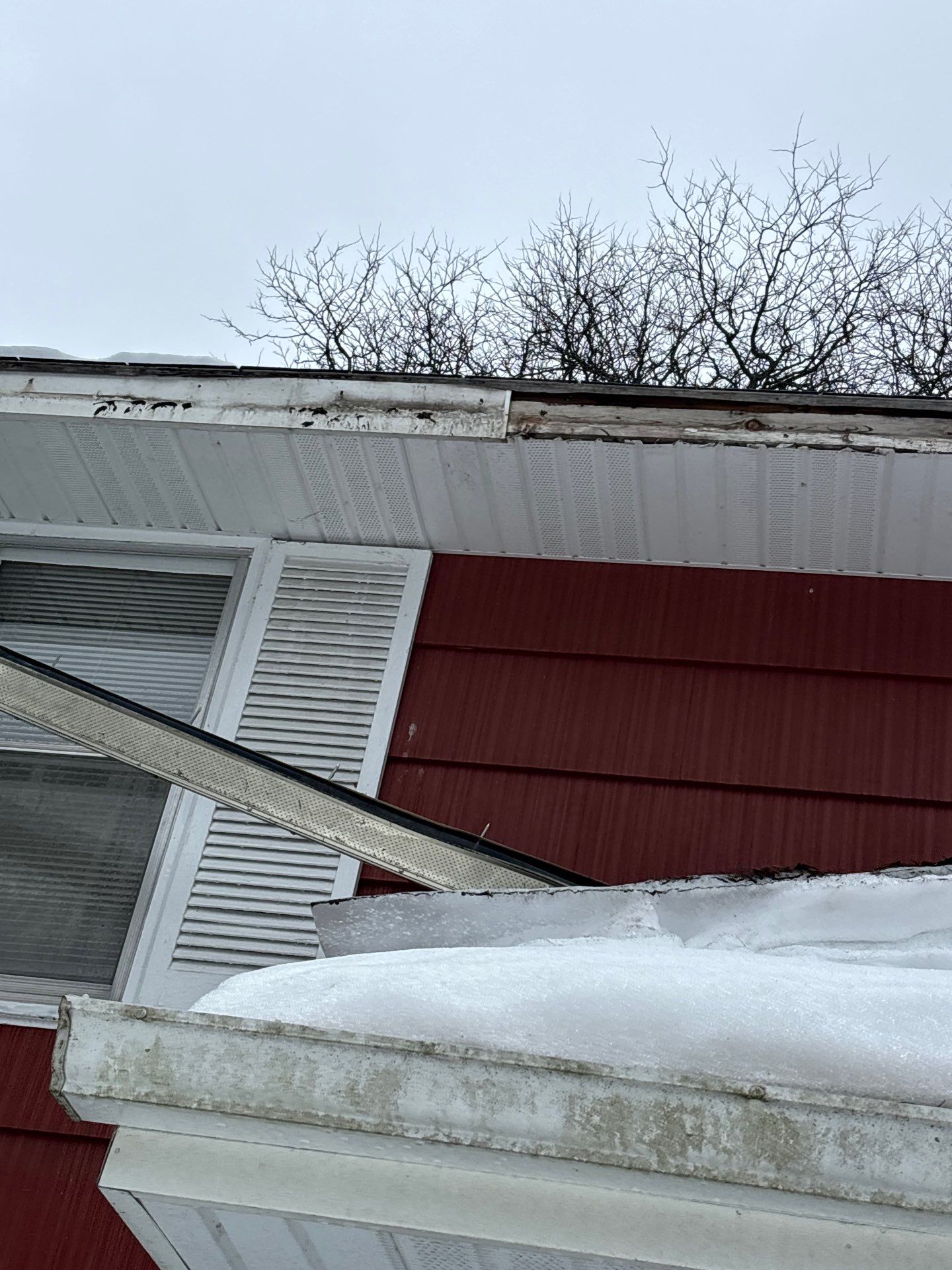 Gutters and gutter guards torn away from roofline by ice dam damage