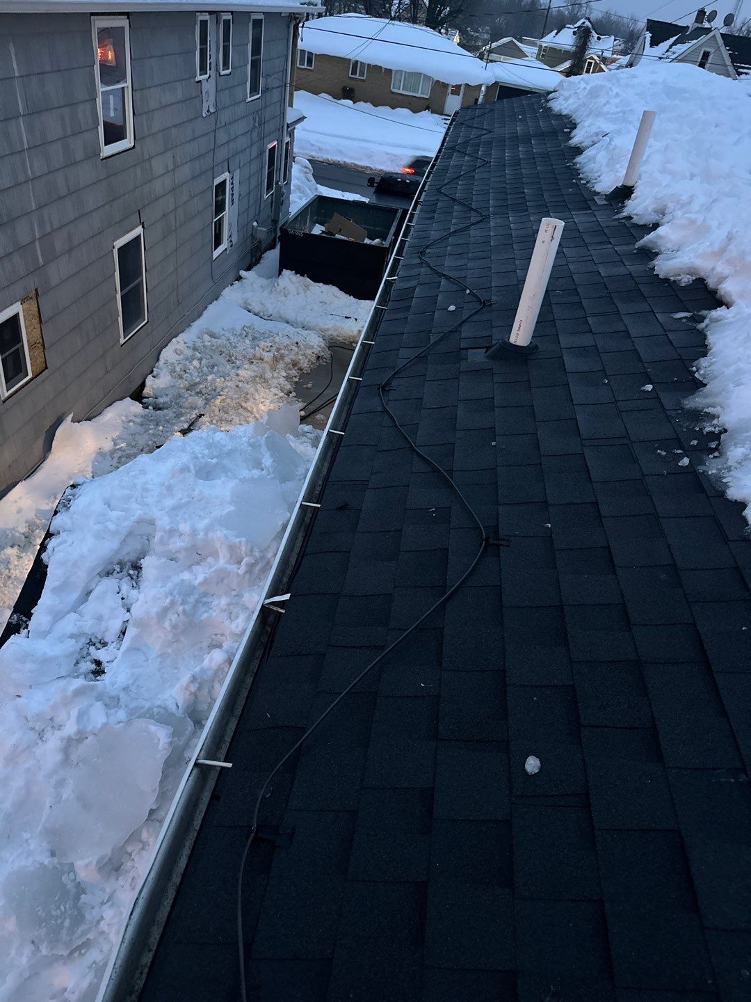 Snow-covered roof with heat cables installed along gutter edge to prevent ice dams