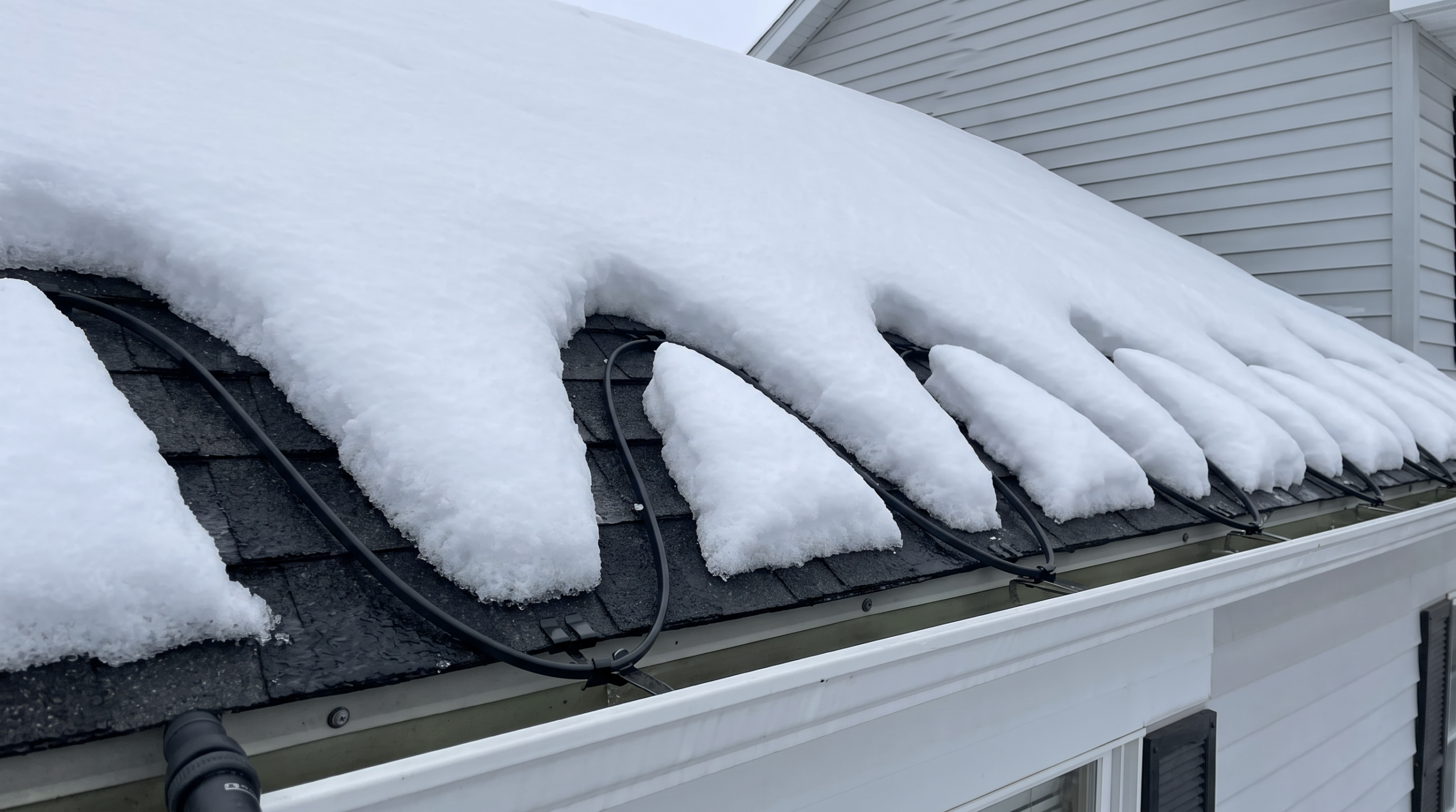 Heat cable melting drainage channels through heavy snow on roof edge