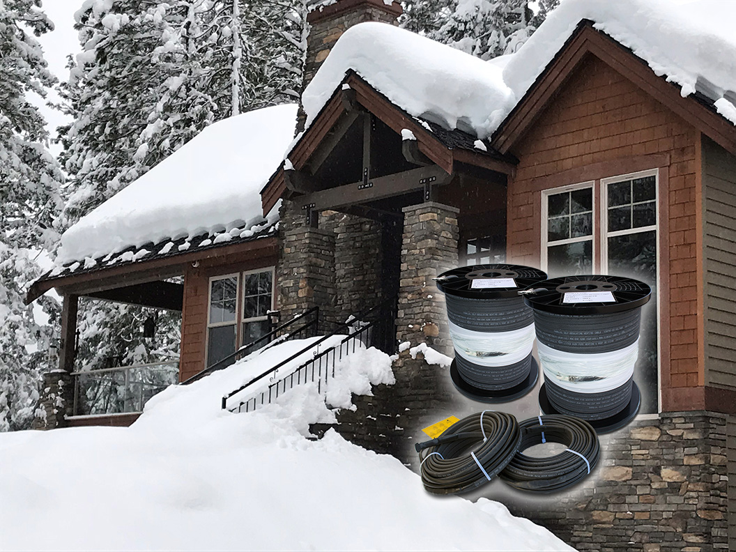 Snow-covered cabin in winter with roof edge heat cable spools and pre-terminated cable sets