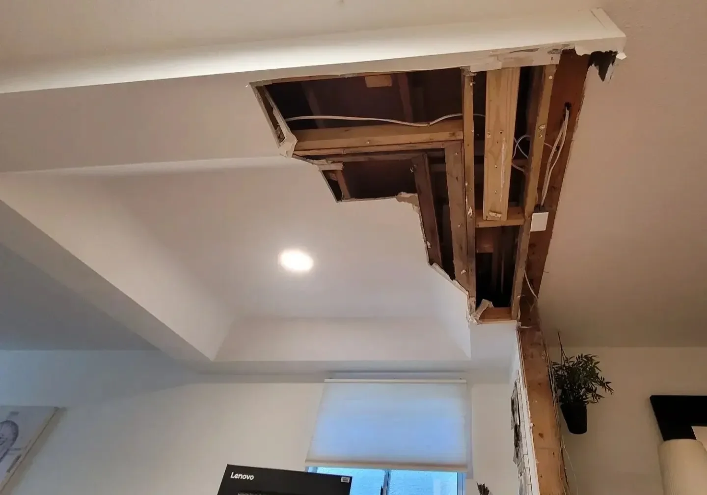 collapsed drywall ceiling exposing wood framing and electrical wiring after ice dam water damage